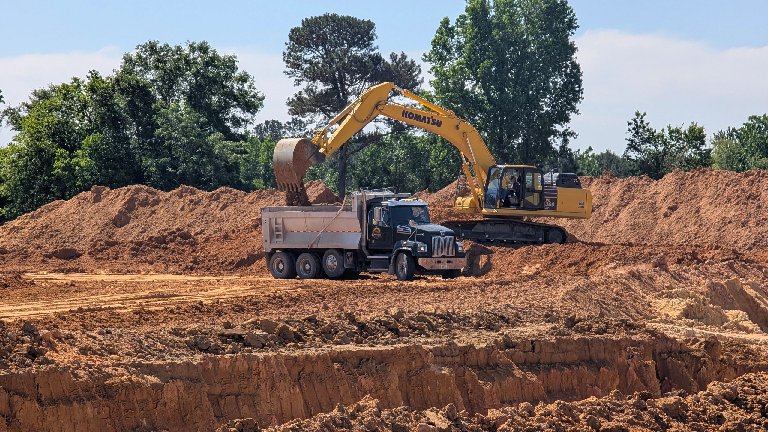 Excavator loading soil into dump truck